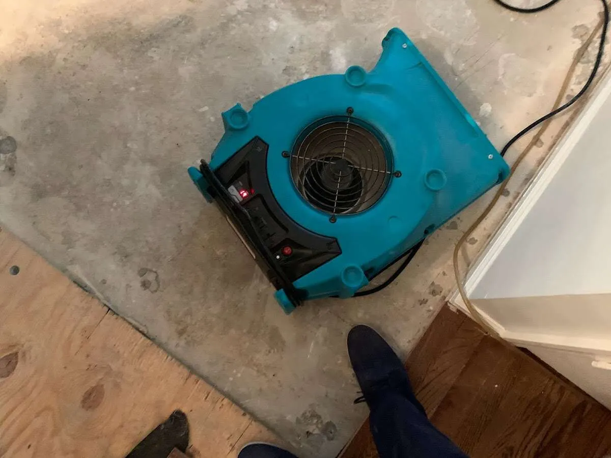 Air mover drying subfloor during Leak Detection & Repair in Edgerton